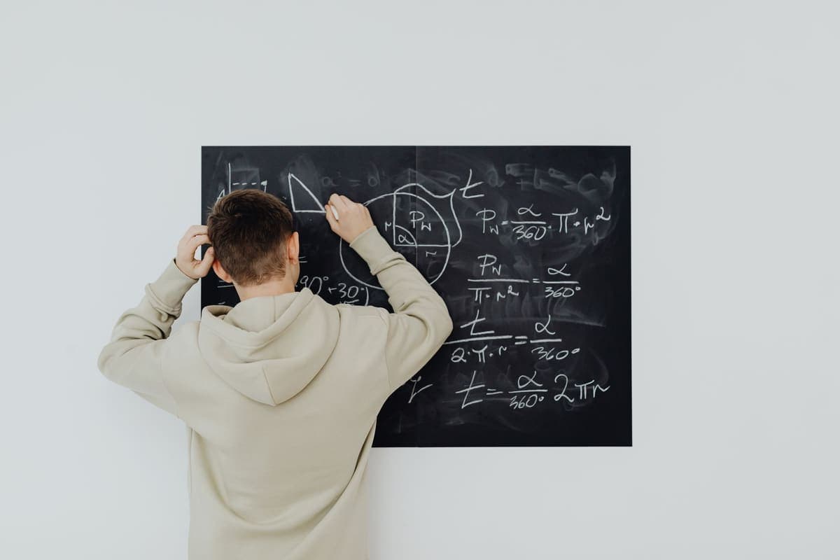 Karatahtada matematik problemi çözen lise öğrencisi